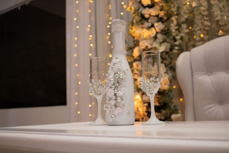 Beautifully decorated champagne bottle and glasses on a wedding table.