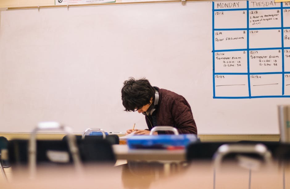 A high school student studying and solving problems in a classroom setting.