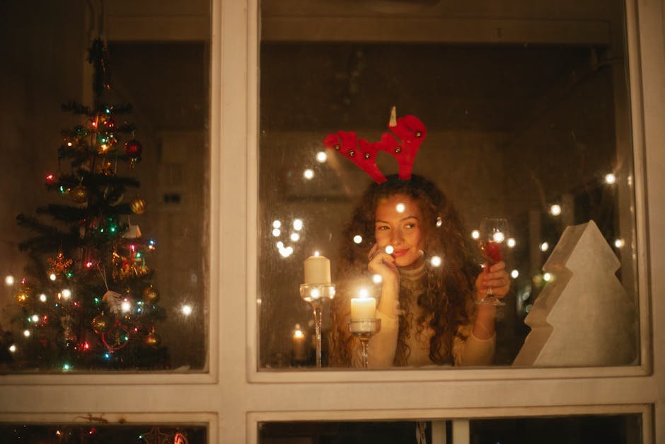 Woman with antler headband enjoying festive evening by candlelight through a window