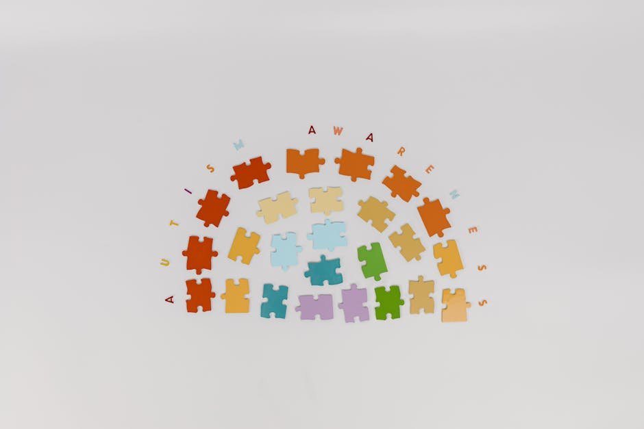 Colorful puzzle pieces arranged to promote autism awareness on a light background.