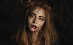 Eerie portrait of a woman with intricate face paint and dark makeup, perfect for Halloween themes.