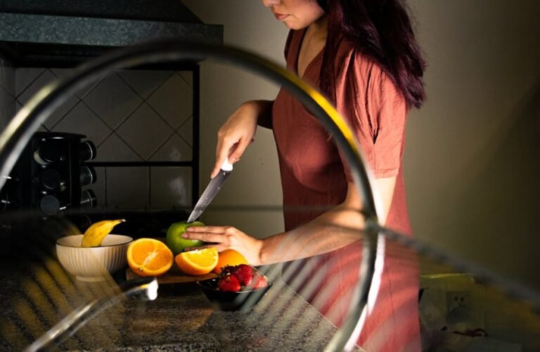 A woman slices fruits on the kitchen counter, showcasing a healthy lifestyle.