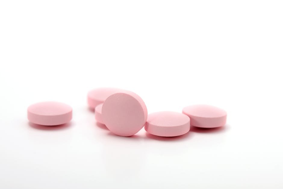 A detailed image of pink medication tablets arranged on a clean white background.