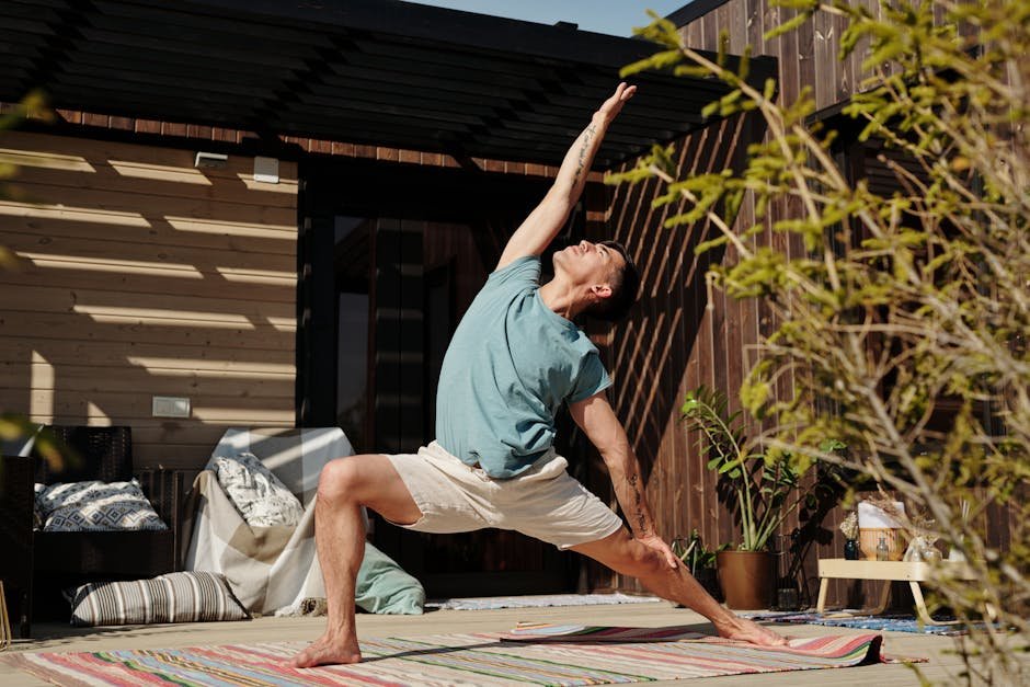Adult male performing yoga on a veranda, enjoying a healthy lifestyle outdoors.